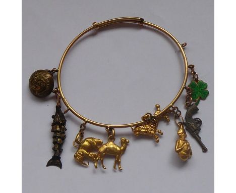 A rose-gold coloured bangle mounted with various charms including a yellow-metal camel and lion etc.&nbsp;