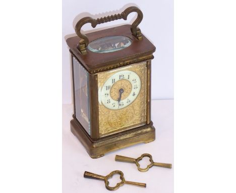 A late 19th century gilt-metal and glass-sided carriage time piece, the cream enamel dial with Arabic numerals within an orna
