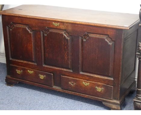 A mid-18th century oak mule chest of large proportions, the hinged moulded lid over a three-fielded panel front and two half-