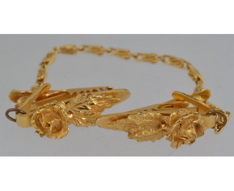 A vintage 1950s gold tone sweater guard,  cardigan clip, cloak clasp embellished with with roses on clip with adjoining gold 