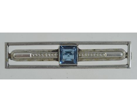 An French Art Deco white metal brooch with central square cut stone with trombone clasp. Measures 5.5cms