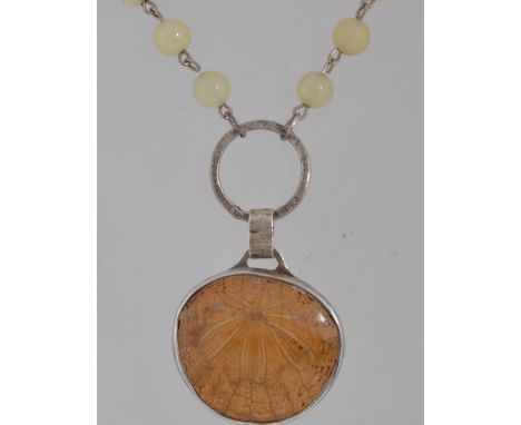 A 925 silver pendant necklace strung with a large sea urchin fossil with agate beads and  large hook clasp.Measures 16 inches