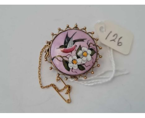 A gold and enamel circular brooch with bird design