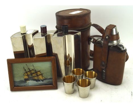 A leather cased glass hip flask and a three bottle tin lined flask set with four shot glasses, together with a reverse painte