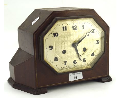 A early 20th century mantle clock, the silvered octagonal dial with Arabic numerals, within a geometric mahogany vase, moveme