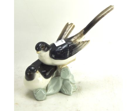 A Lladro ceramic figural group depicting two birds perched upon branches, 18cm high