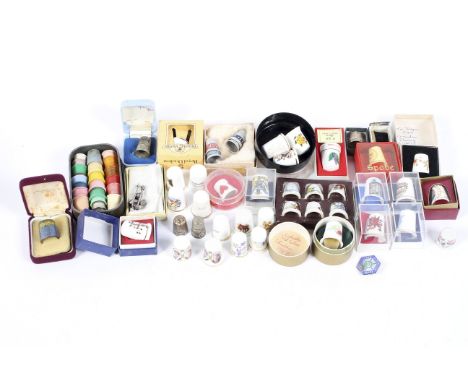 A collection of assorted thimbles, comprising mostly ceramic pieces and some silver examples