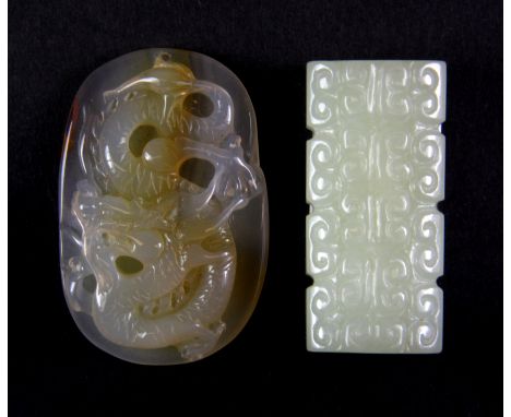 A carved chalcedony amulet of a dragon (H. 5cm), together with a carved jade bead, H. 4.5cm.
