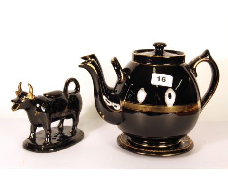 A rare 19th century double spout black glazed and gilt pottery teapot (H. 19cm, spout to handle 28cm) with stand and cow crea