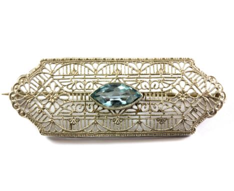 A 1930's American 10ct white gold (stamped 10k) filigree brooch set with a marquise cut light blue topaz, L. 4.5cm.