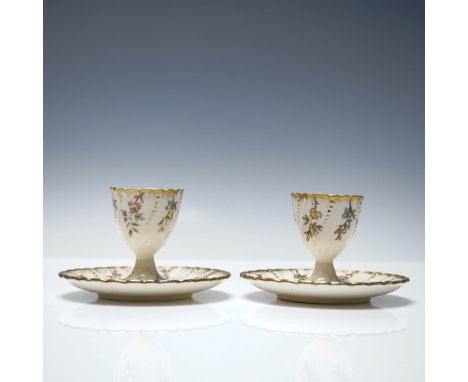 Pair of antique French faience egg cups with matching saucers by Sarreguemines, decorated in the Louis XV pattern. Each pedes