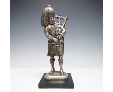 A finely cast silver-toned sculpture titled The Piper, depicting a traditional Scottish bagpiper in full Highland dress, comp