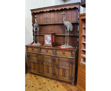 Carved oak dresser with shelf back above three drawers and three cupboard doors, 137cm