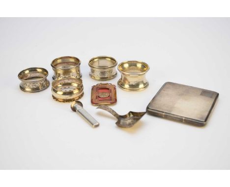 A small collection of silver, comprising; an engine turned cigarette case, five napkin rings, a caddy spoon and a stem holder