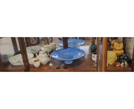 A large Clutha blue glass dish 36.5cm diameter, ten ceramic and metal owls, a pair of Sadler wavy-line pattern teapots, Crown