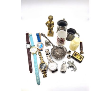 A box of knick-knacks including a white metal spoon with cherub decoration, a ceramic tumbler, a wax seal letter B, two minia