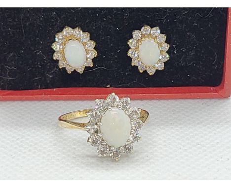 A 9ct yellow gold ring and earring set natural opal and paste stone surrounds. ring size O 1/2.  Total weight 4.1gms.
