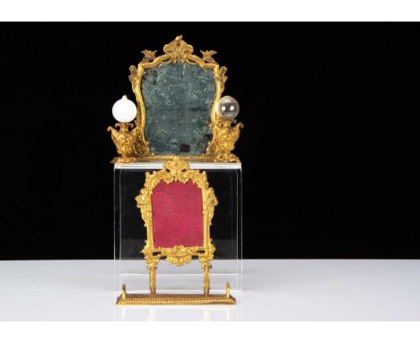 Gilt metal dolls’ house chattels, an overmantel mirror —4in. (10cm.) high, a firescreen, two lamps with glass shades and a fe