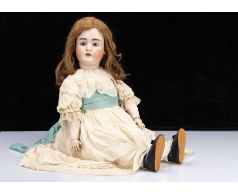 A large Konig & Wernicke 4711 child doll, with blue sleeping eyes, brown feathered brows, auburn hair wig, jointed compositio