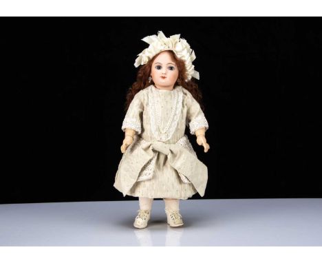A late 19th century French bebe impressed M G on Jumeau body, with fixed blue glass eyes, dark brown brows, closed mouth, pin