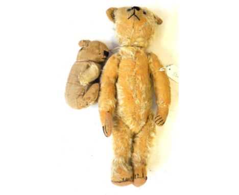 A pre-war gold plush teddy bear
With black button eyes and articulated limbs, height 42cm and another small bear, height 15cm