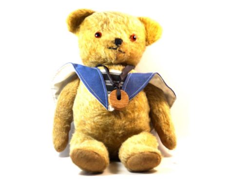 A 1940s English gold plush teddy bear
With glass button eyes and articulated limbs, in blue and white sailor top, height 44cm