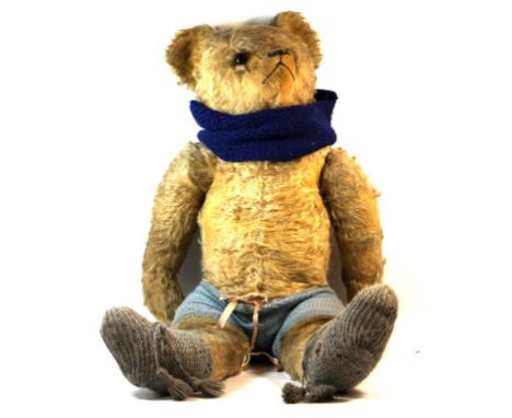 A good quality large gold plush teddy bear
With pointed snout, glass button eyes and articulated limbs, height 60cm.