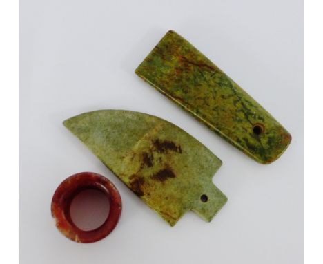A red hardstone archery ring, together with two green hardstone axe heads, (3) 