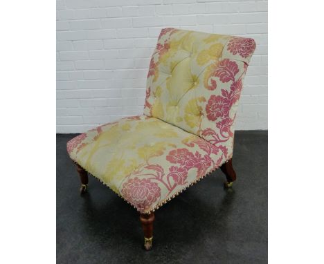 A floral upholstered button back chair on mahogany supports terminating on brass caps and castors, 86 x 75cm