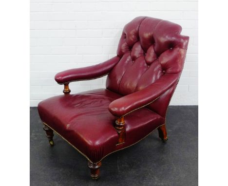 A red leather button back library chair  armchair, on mahogany turned supports with brass caps and castors,  92 x 78cm