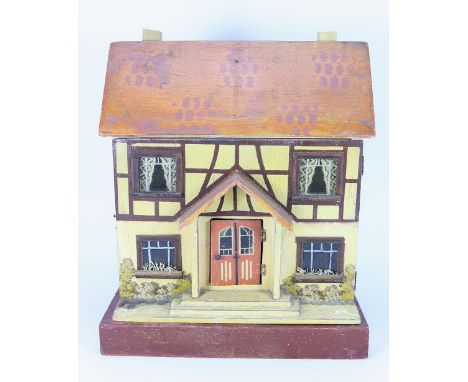 A D.H Wagner & Son painted wooden dolls house with contents, German 1920s-30s, the painted cream façade with painted shrubber