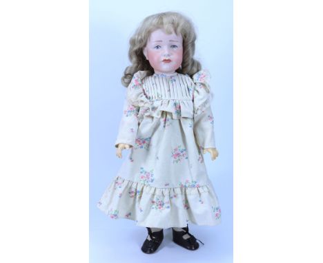 A reproduction Kammer & Reinhardt 114 bisque head doll, 1982 with painted blue eyes, closed mouth and blonde wig, on a fully 