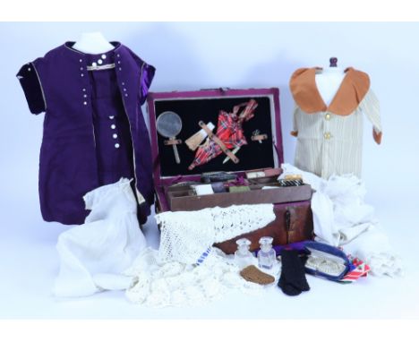 A brown leather dolls trunk with clothes and accessories,  with initials P.J.D and tag ‘To Pat, with lots of love from mama’,