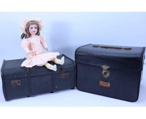 An A.M ‘Floradora bisque head doll in trunk with selection of clothes, with weighted blue glass eyes, open mouth, (lacks teet