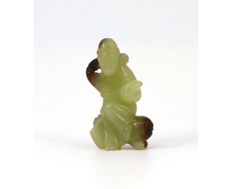 A Chinese yellow and brown jade figure of a man seated on a creature, 19th century, the greenish yellow stone with dark brown