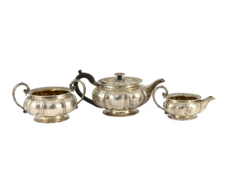 A George IV silver three piece tea set by Benjamin Smith III, of squat melon form, with ornate engraved crest and fluted bord