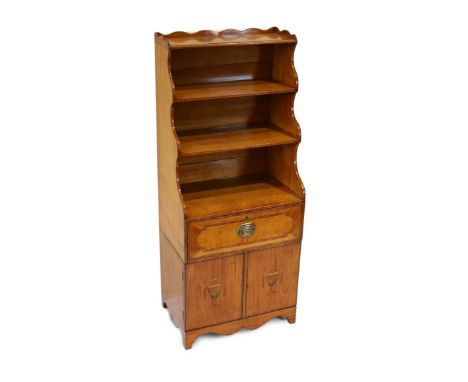 A George III Sheraton style inlaid satinwood waterfall bookcase, with three open shelves over a deep drawer and two cupboard 
