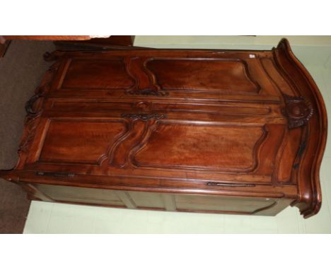 An 18th century French fruitwood or cherry armoire, the moulded pediment above fielded cupboard doors enclosing later shelves