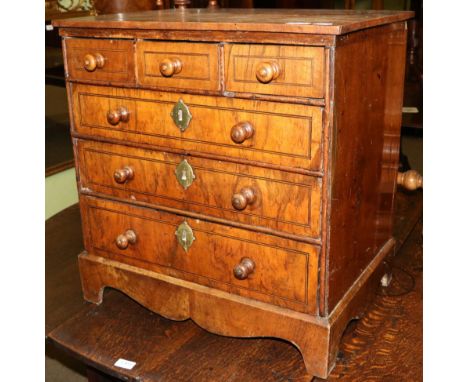A George II walnut, boxwood and ebony strung miniature chest, of three short over three long graduated drawers, on a shaped p