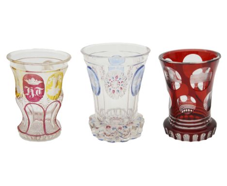 Three late 19th century Bohemian glass spa beakersfirst of flared faceted form with a petal foot, the body of the beaker with