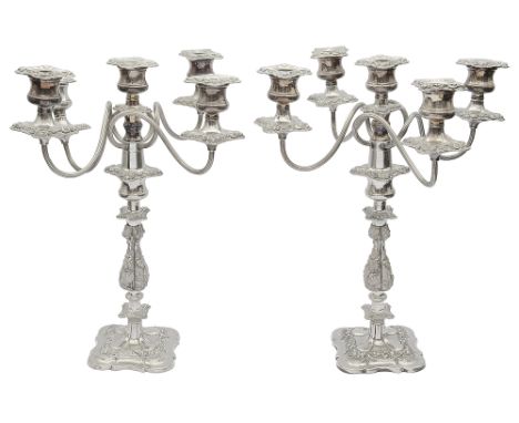 A pair of mid 20th silver plated five light candelabra in late Georgian stylehaving foliate embossed stems and borders on sha