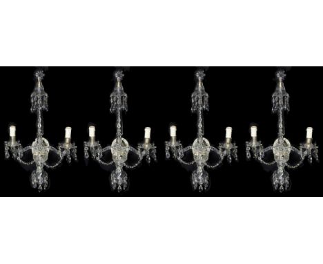 A set of four George III style cut glass twin light wall appliques each having an oval silvered mirror backplate issuing a pa