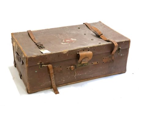 A vintage travel trunk with leather straps, the end initaled MMB, with travel sticker 