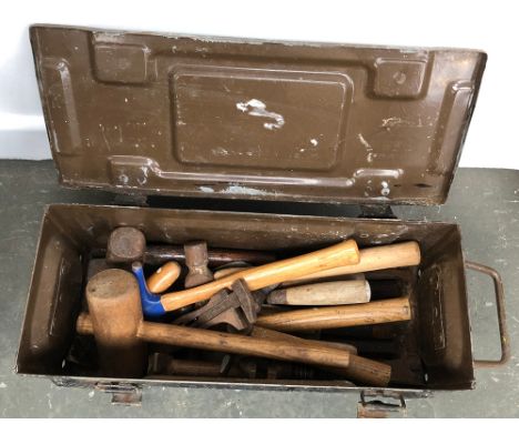 A vintage metal ammo box, containing a number of vintage tools, mostly hammers, wrenches, and chisels 