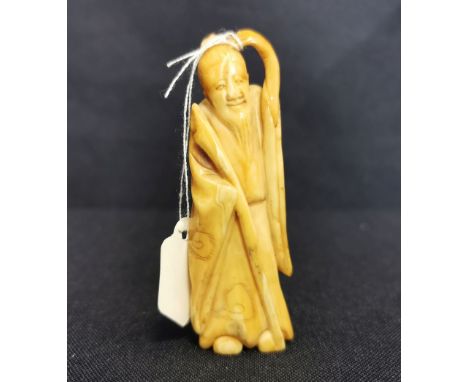 NETSUKE: STEHENDER MANN MIT STAB, Japan, wohl Horn, partiell gebräunt, ohne Signatur. Vollplastische Figur eines stehenden bä