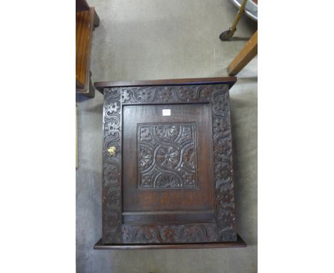 A 17th Century style carved oak wall cabinet 