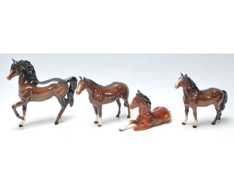 A collection of three vintage mid century Beswick horses finished in dark brown colour, white front legs and black accents to