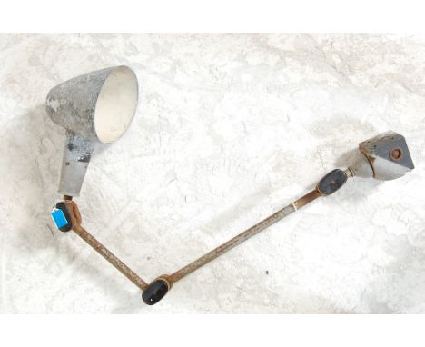 An early 20th century Industrial factory workshop anglepoise lamp with adjustable metal pole and metal mount, bakelite caps t
