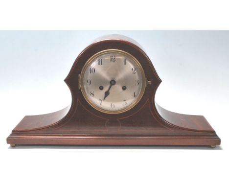 An early 20th Century Edwardian mahogany napoleon's hat mantel clock having inlaid borders with a round face to the centre, s