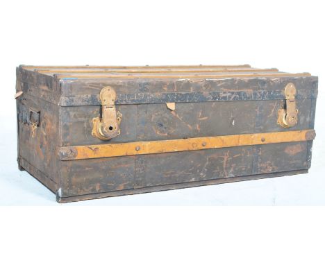 An early 20th century wooden bound steamer trunk with hinged lid, metal locks and banding with riveted details and green stri